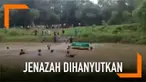 Sejumlah warga nekat menghanyutkan keranda berisi jenazah ke sungai yang arusnya deras.