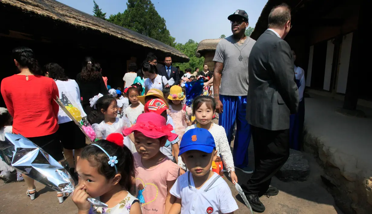 Mantan bintang basket NBA Dennis Rodman bersama anak-anak Korea Utara selama kunjungannya ke Mangyongdae, tempat kelahiran pemimpin Korea Utara Kim Il Sung di Pyongyang, Korea Utara (14/6). (AP Photo/Kim Kwang Hyon)