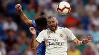 Penyerang Real Madrid, Karim Benzema berebut bola udara dengan pemain Getafe, Leandro Cabrera saat bertanding pada lanjutan La Liga Spanyol di stadion Santiago Bernabeu, Madrid, (19/8). Madrid menang 2-0 atas Getafe. (AP Photo/Andrea Comas)