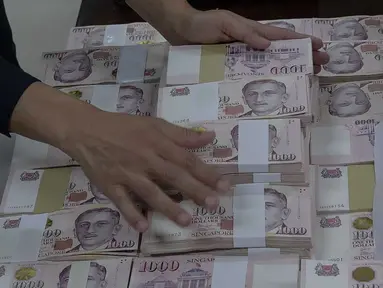 Petugas menata barang bukti terkait penangkapan mantan pejabat Mahkamah Agung Zarof Ricar di gedung Kejaksaan Agung, Jakarta, Jumat (25/10/2024). (Liputan6.com/Herman Zakharia)