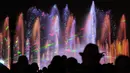 Pengunjung menyaksikan air mancur menari pada awal musim semi di taman Warsawa, Polandia, 1 Mei 2018. Atraksi ini memadukan teknologi pertunjukan lampu laser tiga dimensi, semburan menara api, layar air digital serta pancuran air. (AP/Alik Keplicz)