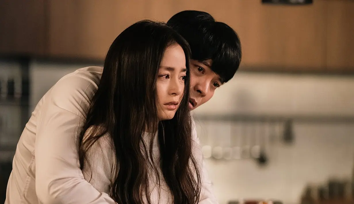 <p>Joo Ran sangat ketakutan karena bau yang tidak dapat dijelaskan datang dari halaman belakang mereka. Jae Ho memeluk Joo Ran dari belakang seolah-olah untuk menenangkannya, tetapi bahkan dalam pelukan penuh kasih Jae Ho, mata Joo Ran masih bergetar. (Foto: ENA via Soompi)</p>