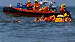 Petugas gendarmerie Prancis mengevakuasi jenazah seorang pria yang ditemukan di perairan dekat Pantai Neufchâtel-Hardelot, Pas-de-Calais, Rabu (23/9/2026). Penemuan jenazah terjadi setelah upaya penyeberangan sejumlah migran menuju Inggris melalui Selat Inggris. (Sameer Al-DOUMY/AFP)