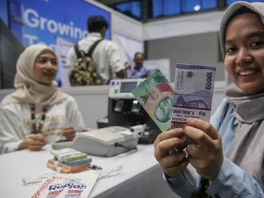 Warga menunjukkan uang rupiah baru usai melakukan penukaran di Hall Basket, Kompleks Gelora Bung Karno, Senayan, Jakarta, Jumat (21/3/2025). (Liputan6.com/Angga Yuniar)