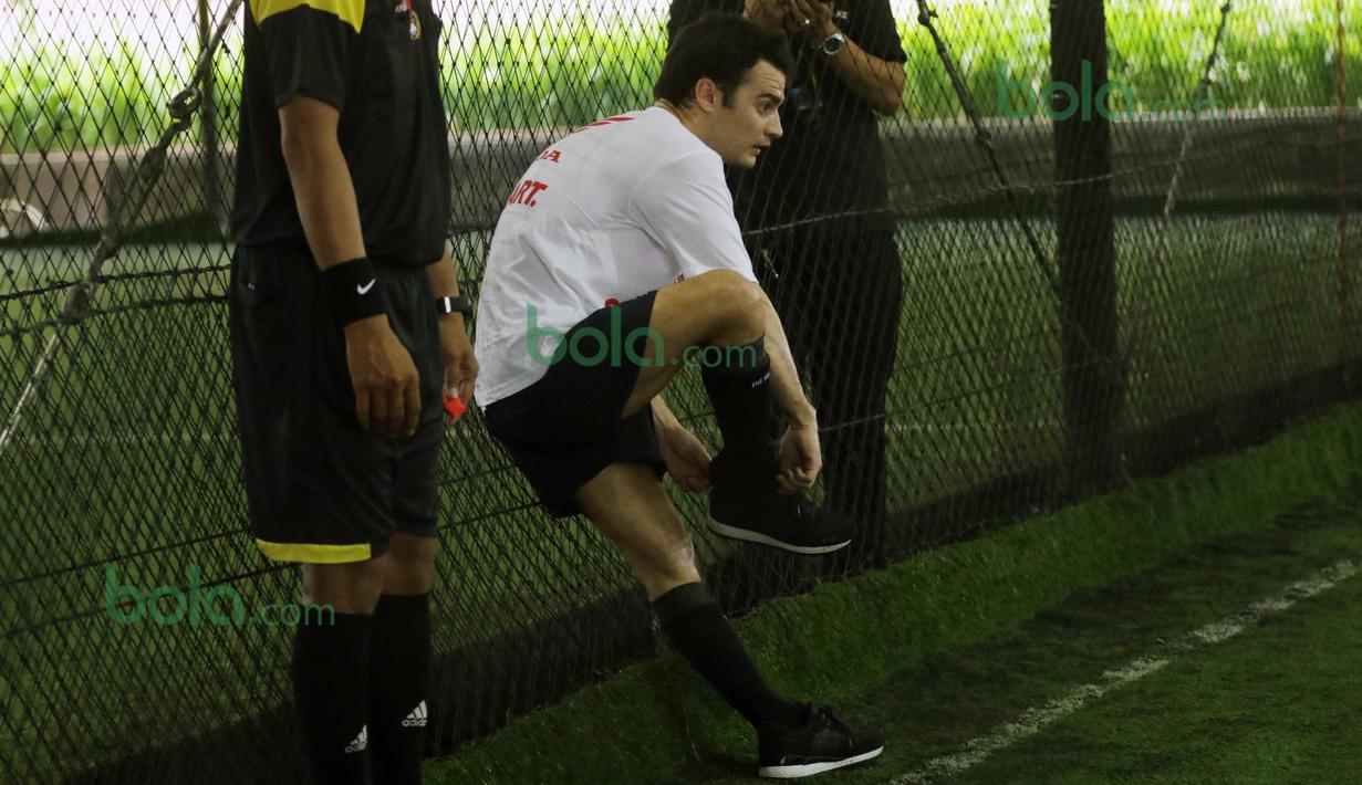 Dani Pedrosa memakai sepatunya yang copot saat bermain futsal di Lapangan Futsal Kuningan Village, Jakarta, Sabtu (13/2/2016). (Bola.com/Nicklas Hanoatubun)