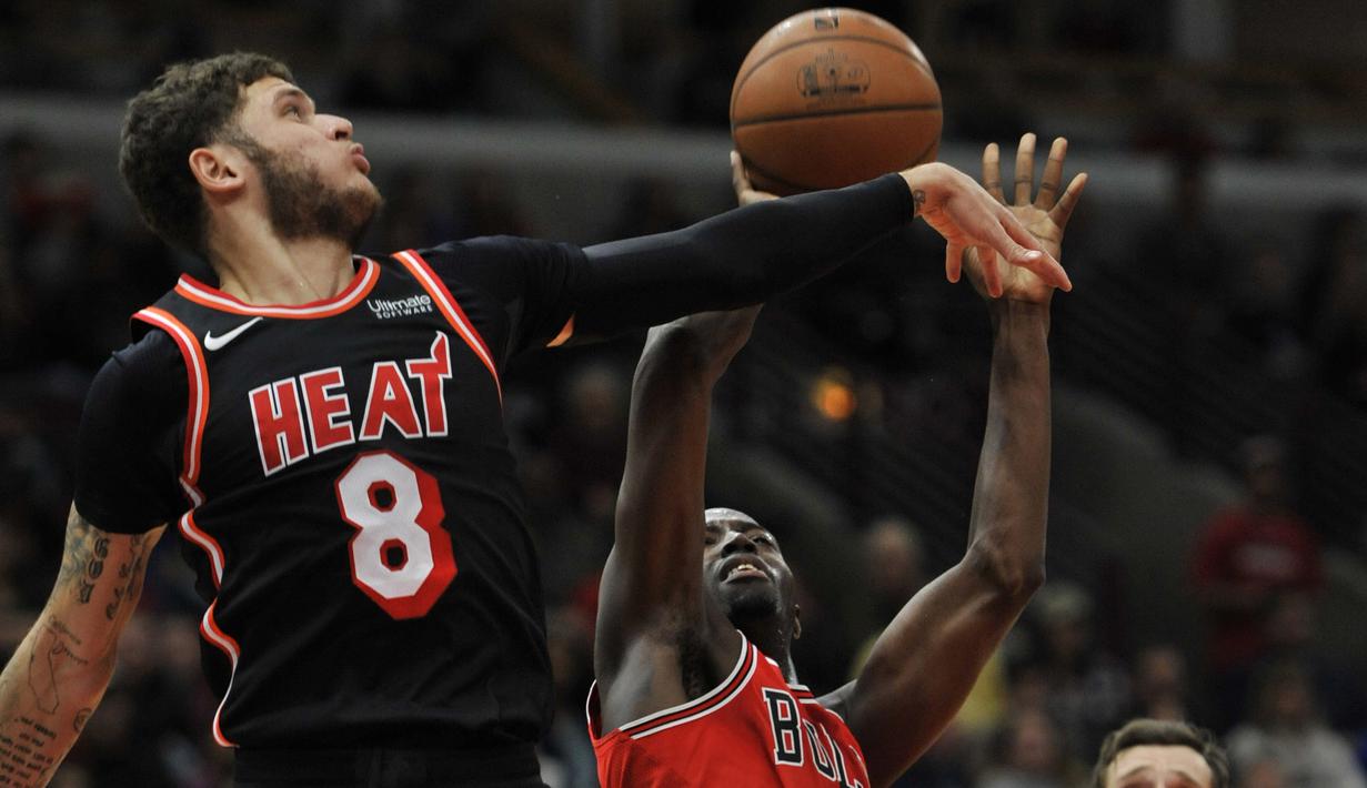 Pemain Miami Heat, Tyler Johnson menghalau tembakan pemain Chicago Bulls, Jerian Grant (kanan) pada laga NBA basketball game di United Center, Chicago, (26/11/2017). Miami Heat menang 100-93.  (AP/Paul Beaty)