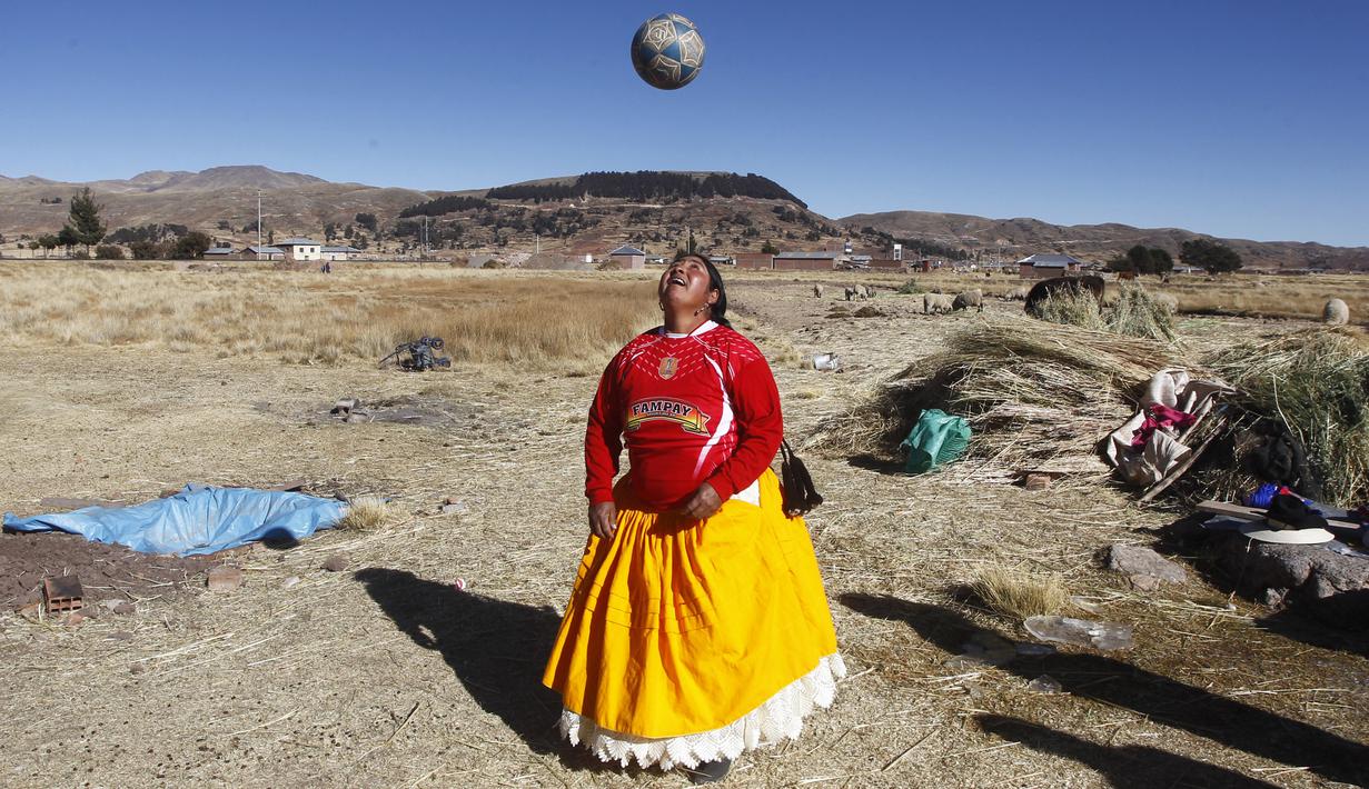 Seorang perempuan suku Aymara berusaha menyundul bola di distrik Juli, kota Puno, Peru selatan. (AFP/Carlos Mamani)