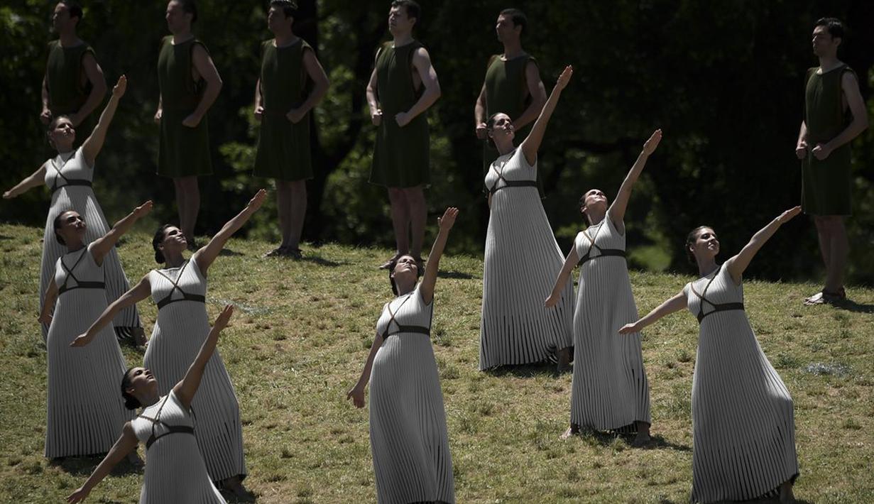 Para aktris menari jelang upacara penyalaan api olimpiade di Candi Hera yang terletak di bekas kota tua Olympia, Yunani, Kamis (21/4/2016). (AFP/Aris Messinis)