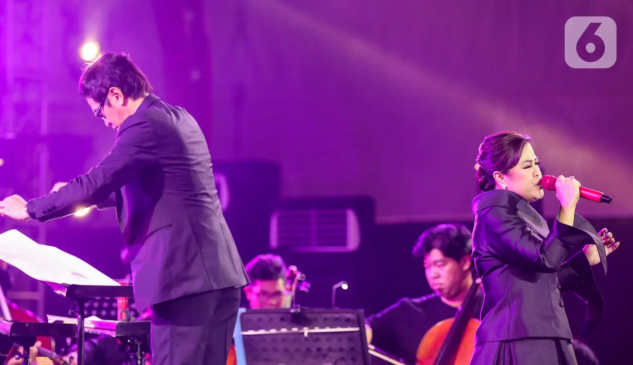 Penyanyi Rita Effendi bersama Twilite Orchestra saat membawakan lagu bertema Symphony Under the Stars: Movie Fest II di Lippo Mall Kemang, Jakarta, Sabtu (26/10/2019). Sejumlah lagu seperti 007 James Bond, Bohemian Rhapsody, Game of Thrones, sampai Aladdin disajikan. (Liputan6.com/Fery Pradolo)