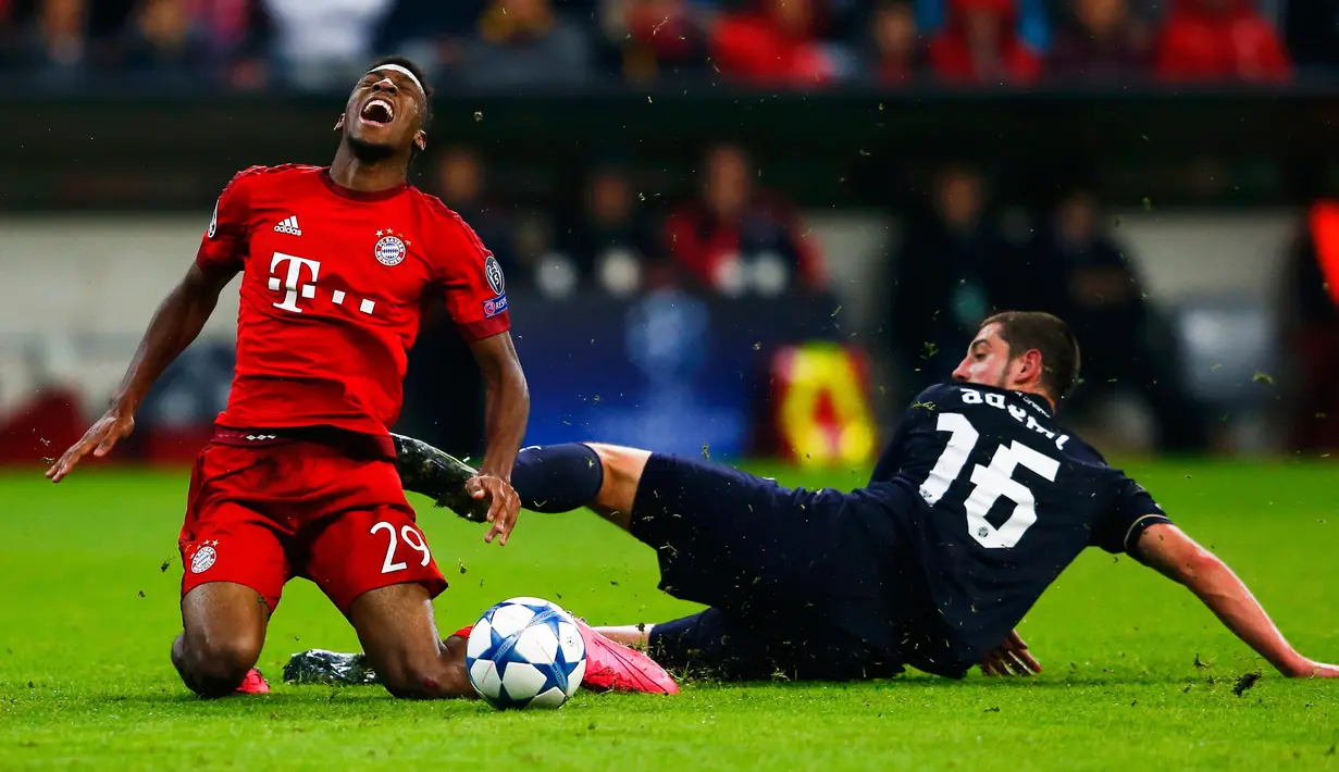 Gelandang Muenchen, Kingsley Coman (kiri) kesakitan saat dilanggar Gelandang Dinamo Zagreb, Arijan Ademi pada laga Liga Champions di Allianz Arena, Jerman (30/9/2015). Muenchen menang telak atas Dinamo Zegreb dengan skor 5-0. (REUTERS/Michael Dalder)