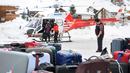 Sejumlah turis turun dari helikopter setelah dievakuasi dari resor ski Zermatt di  Taesch, Pegunungan Alpen Swiss (10/1). Sekitar 13.000 wisatawan terjebak akibat bencana tersebut. (AFP Photo/Fabrice Coffrini)
