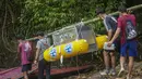 Tim konservasi memasang pelampung keselamatan berwarna kuning pada kandang berisi orangutan hasil rehabilitasi sebelum diangkut menggunakan perahu motor di dekat Desa Batu Lapis, Kabupaten Ketapang, Kalimantan Barat, Kamis (29/10/2026). Orangutan tersebut merupakan satu dari sembilan individu yang diselamatkan dari kebakaran hutan. (Ilham Pratama/AFP)