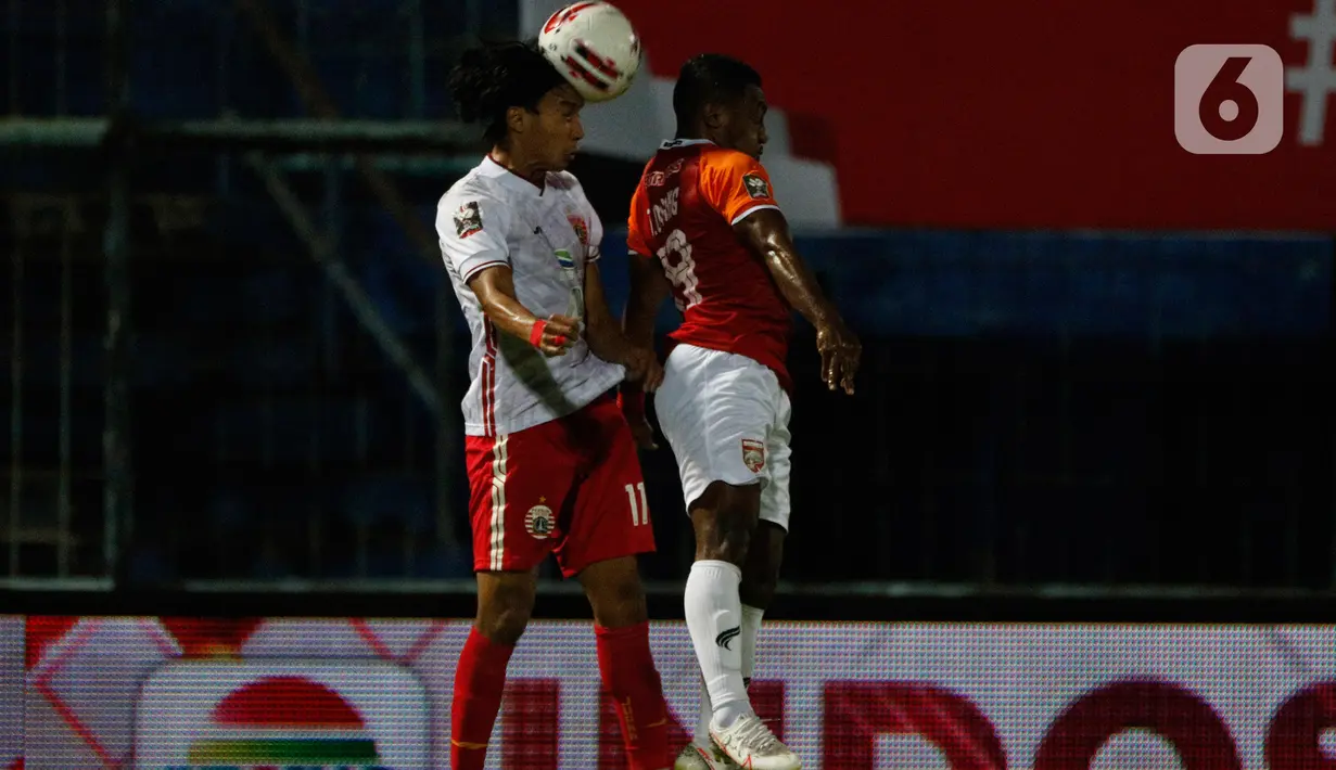 Pemain Persija Jakarta, Novri Setiawan (kiri) berebut bola di udara dengan pemain Borneo FC Samarinda Ahmad Surahman dalam pertandingan Babak Penyisihan Grup B Piala Menpora 2021 di Stadion Kanjuruhan, Malang, Sabtu (27/3/2021). (Bola.com/Ikhwan Yanuar)