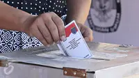 Warga memasukkan surat suara ke dalam kotak suara saat menggunakan hak pilih pada pemungutan suara Pilkada Depok di TPS Kampung Pilkada RW 03, Depok, Jawa Barat, Rabu (9/12). (Liputan6.com/Immanuel Antonius)