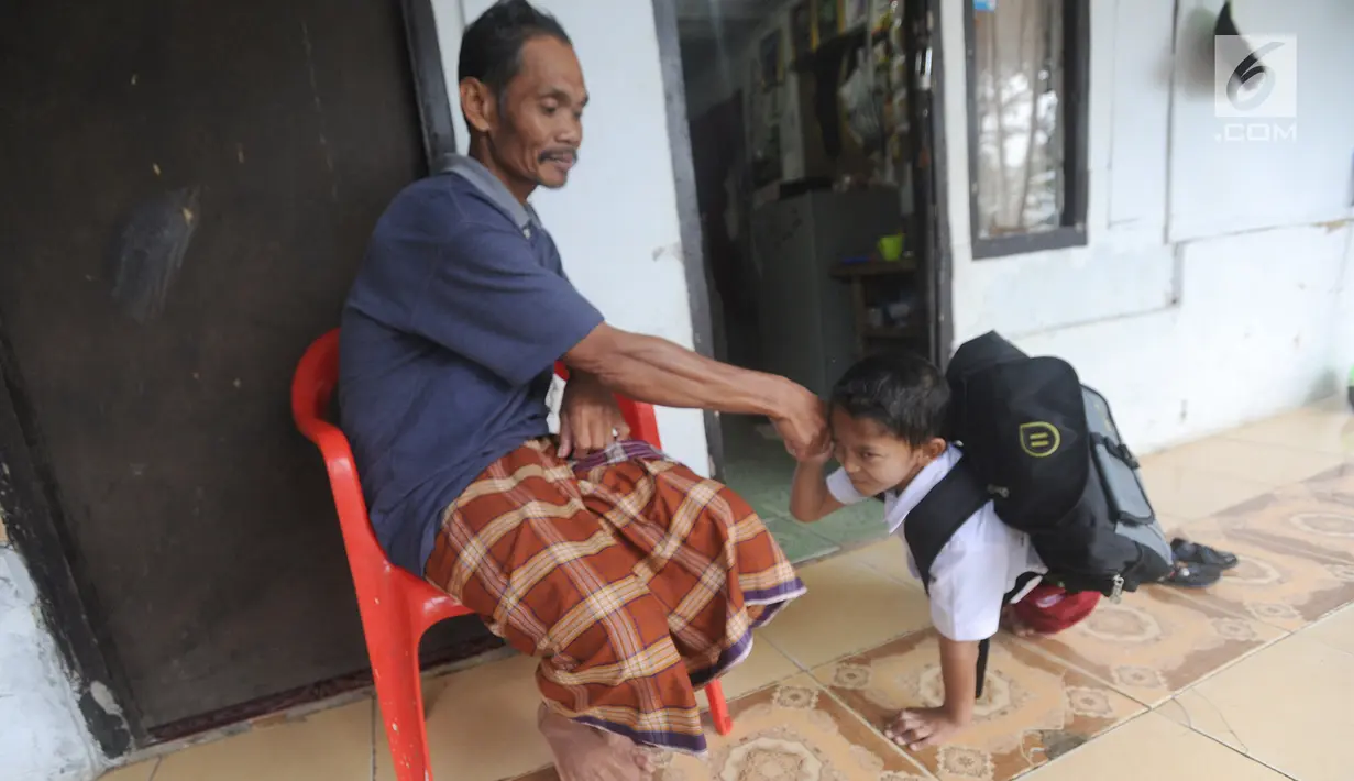 Mukhlis Abdul Holik (8)  berpamitan sebelum berangkat menuju sekolahnya di Kampung Cikiwul Tonggoh, Sekarwangi, Sukabumi, Kamis (15/11). (Merdeka.com/Arie Basuki)