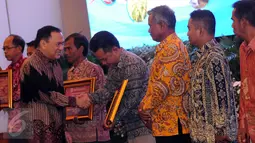 Gubernur Bank Indonesia, Agus DW Martowardojo (kiri) memberikan penghargaan program pengendalian inflasi 2016 di Jakarta, Senin (25/4/2016). 13 klaster dinilai sukses mengembangkan program pengendalian inflasi. (Liputan6.com/Helmi Fithransyah)