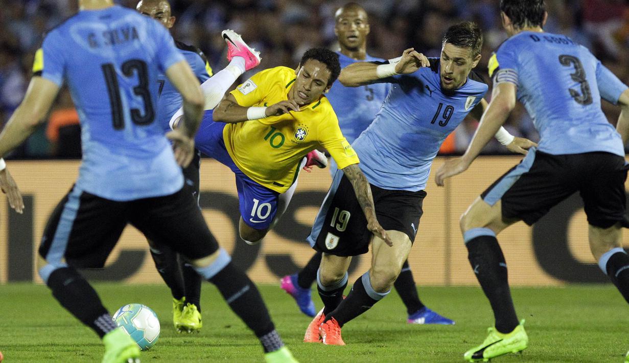 Striker Brazil, Neymar, berebut bola dengan pemain Uruguay. Neymar ikut memperbesar keunggulan dengan menciptakan gol tambahan pada menit ke-74. (AP/Matilde Campodonico)