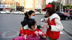 Relawan masyarakat Wang Shujia (kanan) memeriksa suhu tubuh warga di Hefei, Provinsi Anhui, China timur (5/3/2020). Wang Shujia, seorang mahasiswi, ambil bagian dalam tim relawan masyarakat di Hefei untuk membantu mencegah dan mengendalikan epidemi virus corona. (Xinhua/Liu Junxi)