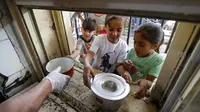 Anak-anak yang membutuhkan antre untuk menerima makanan berbuka puasa dari juru masak di dapur Masjid Muslim Sunni Abdel Kader al-Kilani, Baghdad, Irak, 19 April 2021. Kegiatan ini berlangsung selama bulan suci Ramadhan. (AHMAD AL-RUBAYE/AFP)