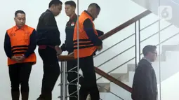 Selanjutnya, Bupati Tulungagung, Gatut Sunu Wibowo beserta ajudannya, Dwi Yoga Ambal, akan menjalani masa penahanan pertama selama 20 hari pertama, terhitung sejak 11 hingga 30 April 2026. Tampak dalam foto, Bupati Tulungagung, Gatut Sunu Wibowo (kedua kanan) bersama ajudannya, Dwi Yoga Ambal (kiri) dibawa petugas menuju mobil tahahan usai menjalani pemeriksaan intensif di Gedung Merah Putih Komisi Pemberantasan Korupsi (KPK), Jakarta, Minggu (12/4/2026) dini hari WIB. (Liputan6.com/Helmi Fitrhiansyah)