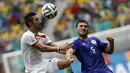 Pemain depan Iran, Reza Ghoochannejhad (kiri) melompat merebut bola dari Sead Kolasinac (Bosnia)  saat berlaga di penyisihan terakhir Piala Dunia 2014 Grup F di Stadion Fonte Nova, Salvador, Brasil, (25/6/2014). (REUTERS/Sergio Perez)