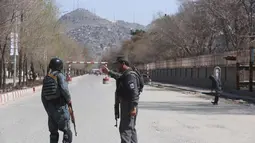 Polisi berpatroli di jalan-jalan setelah serangan bunuh diri di depan Universitas Kabul, Afghanistan, (21/3). Pejabat Afghanistan melaporkan ledakan tersebut di saat warga merayakan Tahun Baru Persia. (AP Photo/Rahmat Gul)