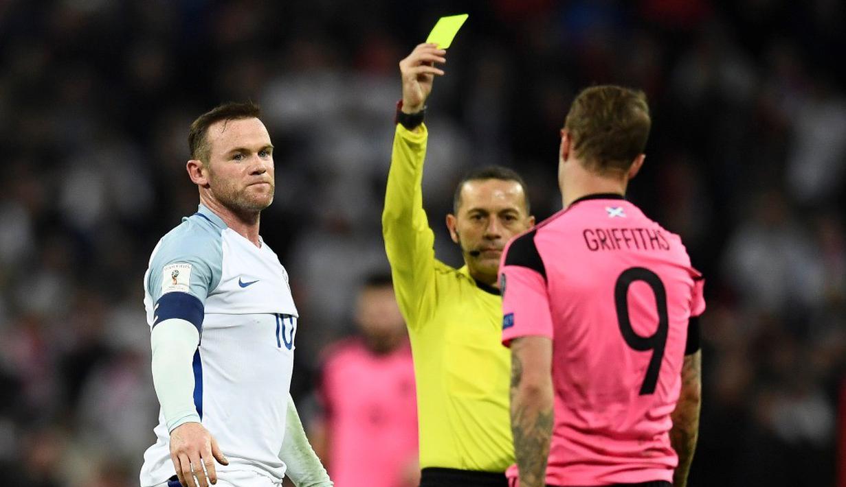 Wayne Rooney (kiri), menerima kartu kuning dari wasit Cuneyt Cakir setelah melanggar Leigh Griffiths dalam laga Grup F Kualifikasi Piala Dunia 2018 di Stadion Wembley, Jumat (11/11/2016) waktu setempat. (Reuters/Dylan Martinez)