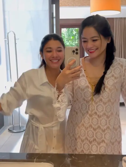 Titi Kamal dan Naysila tampil kompak mengenakan dress putih. Naysila tampil dengan model dress kemeja lengan panjang dan Titi Kamal dengan mini dress lace. [@titi_kamall]