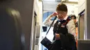 Pramugari tertua di maskapai American Airlines, Bette Nash membawa barang-barangnya sebelum melakukan penerbangan ke Boston di Bandara Ronald Reagan Washington di Arlington, Virginia (19/21). (AFP Photo/Eric Baradat)