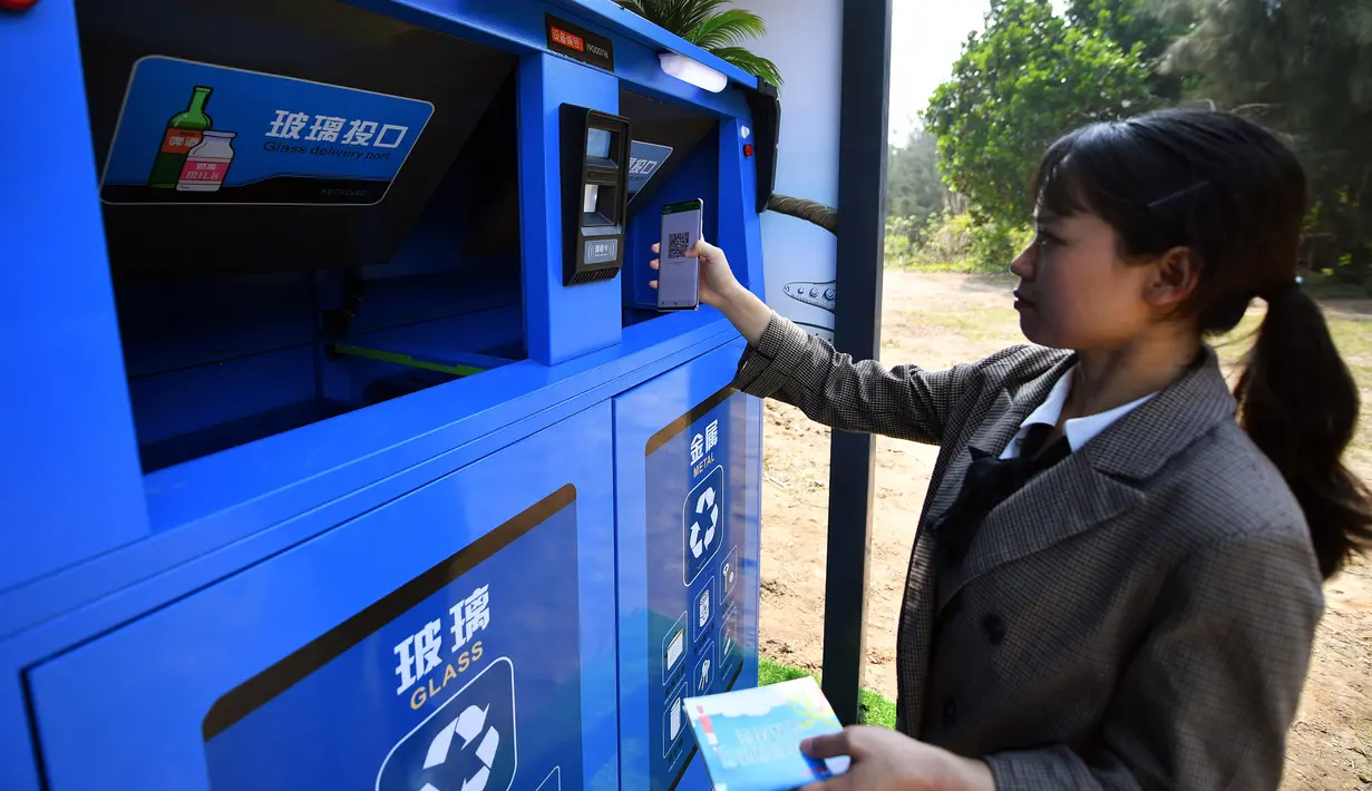 Staf menunjukkan cara menggunakan bank sampah di Teluk Mulan, Kota Wenchang, Provinsi Hainan, China, 28 April 2020. Fasilitas bank sampah dibuat dengan wisatawan dapat menukarkan sampah yang dikumpulkan di pantai dengan hadiah, seperti air kemasan, kelapa, serta makanan ringan. (Xinhua/Guo Cheng)