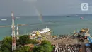 <p>Keindahan pelangi saat menghiasi langit Pelabuhan Merak, Banten, Sabtu (30/4/2022). Kemunculan pelangi tersebut menjadi pemandangan yang indah bagi para pemudik yang ingin menyebrang ke pulau Sumatra. (Liputan6.com/Angga Yuniar)</p>