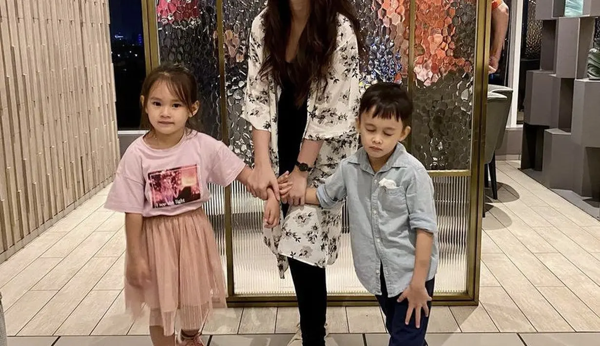 Bersama kedua anaknya, Lady mengenakan outer panjang putih motif bunga dipadukan inner hitam serasi dengan celananya. (@ladykjaernett)