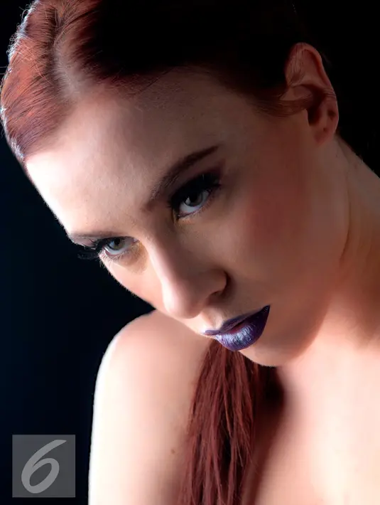 Untuk memberi kesan sensual pada tampilan, Anda dapat menggunakan lipstik warna burgundy atau merah marun. Untuk tampilan yang lebih simpel, padukan dengan riasan mata dengan eyeshadow nude dan eyeliner cateyes. (Liputan6.com/Yudha Gunawan)