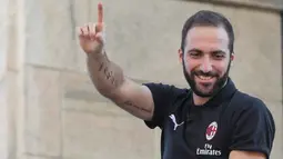 Pemain baru AC Milan, Gonzalo Higuain menyapa suporter dari balkon di alun-alun pusat Milan Piazza Duomo (3/8). AC Milan telah mendatangkan lima pemain baru pada bursa transfer musim panas tahun ini. (AFP Photo/Stringer)
