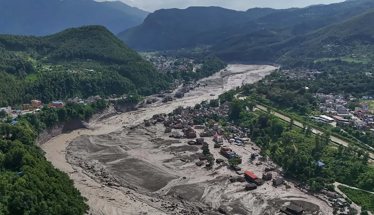 Rumah-rumah yang rusak berdiri dalam kondisi rawan di dekat tepian Sungai Trishuli yang meluap dan dipenuhi puing-puing setelah banjir bandang melanda distrik Nuwakot, Nepal, pada hari Rabu, 26 Agustus 2026. (Foto AP/Niranjan Shrestha)