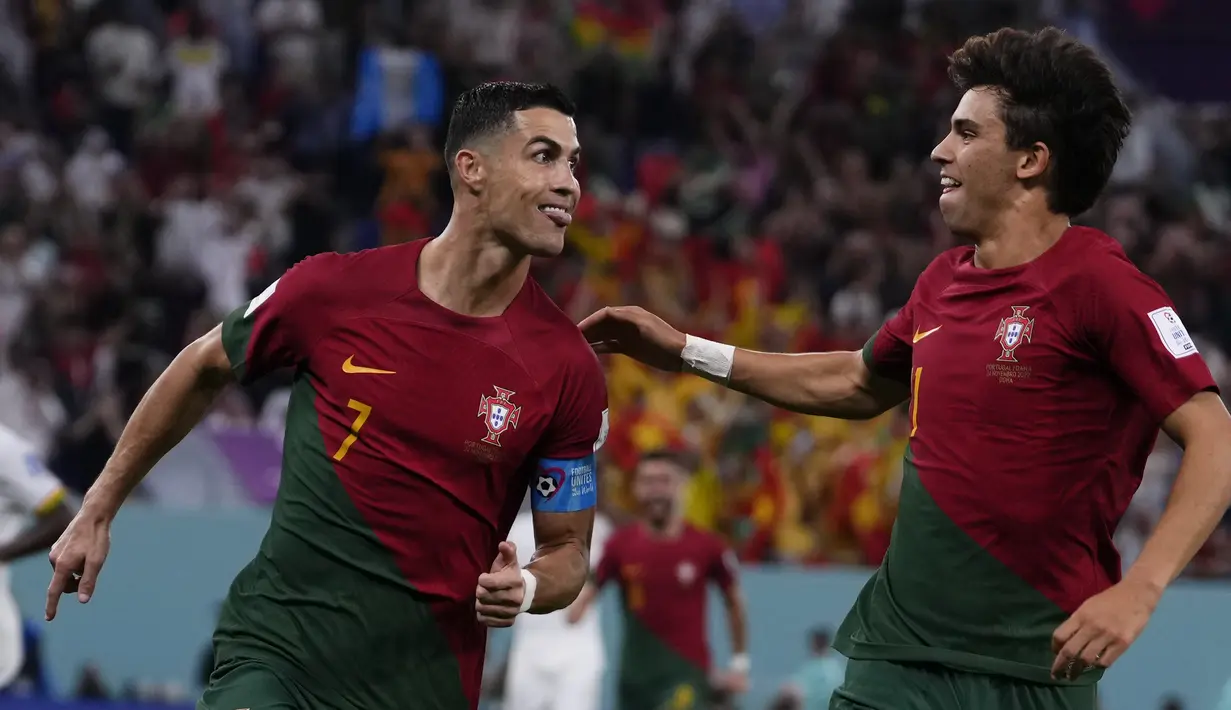 Penyerang Portugal Cristiano Ronaldo berselebrasi dengan rekan setimnya Joao Felix setelah mencetak gol pembuka timnya melalui penalti ke gawang Ghana pada duel grup H Piala Dunia 2022 di stadion 974, Kamis (24/11/2022). Cristiano Ronaldo mencetak satu gol dalam kemenangan 3-2 Portugal atas Ghana. (AP Photo/Manu Fernandez)
