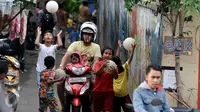 Pengendara motor melintas ketika sejumlah bocah bermain bola di gang kecil kawasan Benhil, Jakarta, Rabu (10/6). Gang kecil itu dimanfaatkan untuk bermain dikarenakan minimnya sarana bermain khususnya lapangan bola di Jakarta. (Liputan6.com/Johan Tallo)