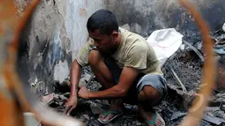 Seorang warga mencari sisa-sisa barang di rumahnya usai kebakaran di Karang Anyar, Sawah Besar, Jakarta, Selasa, (24/2/2015). Kebakaran yang melanda 14 Rukun Tetangga (RT) ini menyebabkan 2.000 warga kehilangan tempat tinggal. (Liputan6.com/Faisal R Syam)