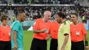 Presiden FIFA Gianni Infantino (tengah) mengenakan seragam wasit melempar koin di samping mantan pemain Brasil Cafu dan mantan pemain Italia Alessandro Del Piero saat ia memimpin pertandingan persahabatan antara FIFA Legends dan pekerja yang berbasis di Qatar di Al Stadion Thumama di Doha (12/12/2022). (AFP/Karim Jaafar)