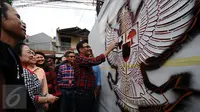 Presiden ke-5 RI Megawati Soekarnoputri menyaksikan Cawagub DKI Djarot Saiful Hidayat mewarnai mural bergambar Garuda Pancasila di dinding TPS tempatnya, di TPS 027 Kebagusan, Jakarta Selatan, Rabu (15/2). (Liputan6.com/Helmi Fithriansyah)