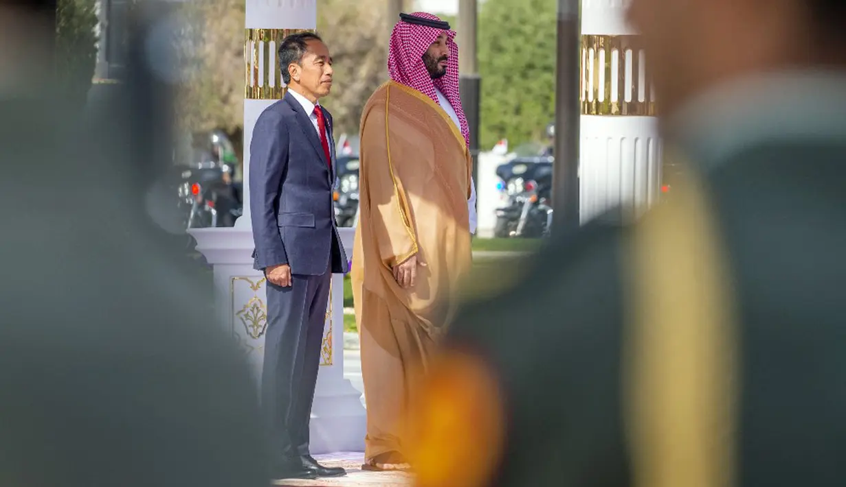 Selanjutnya, kedua pemimpin berjalan masuk menuju lobi Istana Al-Yamamah untuk memperkenalkan delegasi dari masing-masing negara. (Bandar AL-JALOUD/Saudi Royal Palace/AFP)