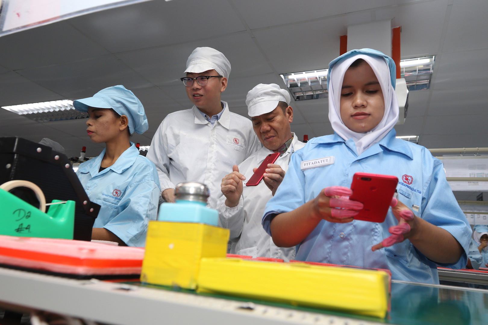 Head of Xiaomi South Pacific Region and Indonesia Country Manager, Steven Shi dan CEO PT Sat Nusapersada Abidin Hasibuan memantau proses perakitan smartphone Xiaomi di pabrik PT. Sat Nusapersada di Batam, Senin (4/12/2017) (Foto: Dok. Xiaomi)