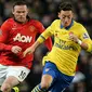 Gelandang Arsenal Mesut Ozil (kanan) berebut bola dengan Wayne Rooney saat pertandingan sepak bola Liga Inggris antara Manchester United melawan Arsenal di Stadion Old Trafford, Manchester (10/11/13) waktu setempat (Foto: AFP/Paul Ellis)