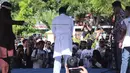 Salah satu dari dua pria terpidana kasus liwath alias gay saat dicambuk di depan Masjid Baiturrahim, Banda Aceh, (13/7). Mahkamah Syariah Kota Banda Aceh menjatuhi hukuman cambuk pasangan gay Nyakrab Bumin dan Muhammad Rustam. (AP Photo/Heri Juanda)
