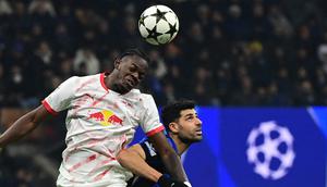 Bek RB Leipzig asal Prancis, Castello Lukeba, berebut bola dengan penyerang Inter Milan, Mehdi Taremi, dalam pertandingan Liga Champions di San Siro, 26 November 2024. (PIERO CRUCIATTI / AFP)