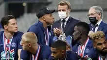Presiden Prancis Emmanuel Macron (tengah) bertepuk tangan saat pemain PSG Kylian Mbappe (kiri tengah) berjalan melewati trofi Piala Prancis usai mengalahkan Saint-Etienne pada laga final di Stade de France, Saint Denis, Paris, Prancis, Jumat (24/7/2020). PSG menang 1-0. (AP Photo/Francois Mori)