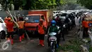 Petugas kebersihan DKI Jakarta melakukan pemotongan pohon tumbang di depan RSCM, Jakarta, Selasa (27/10/2015). Sebuah pohon besar tumbang menutup jalan dan menimpa bus metromini di depan RSCM. (Liputan6.com/Yoppy Renato)