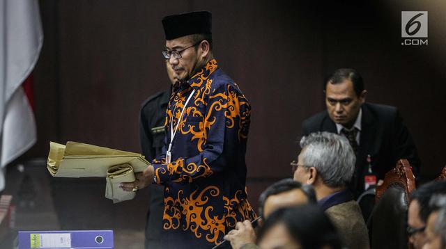 Komisioner KPU, Hasyim Asyari membawa amplop untuk ditunjukkan kehadapan Majelis Hakim dan tim kuasa hukum pasangan Prabowo Subianto-Sandiaga Uno dalam sidang lanjutan sengketa pilpres 2019 di Gedung Mahkamah Konstitusi (MK), Jakarta, Kamis (20/6/2019). (Liputan6.com/Faizal Fanani)