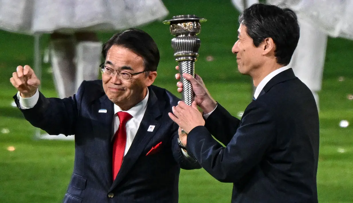Gubernur di prefektur Aichi, Jepang, Ohmura Hideaki (kiri) dan wakil walikota Nagoya, Jepang, Nakata Hideo (kanan) mengambil bagian dalam penyerahan obor pada upacara penutupan Asian Games 2022 yang berlangsung di Hangzhou Olympic Sports Centre Stadium, Hangzhou, China pada Minggu (08/10/2023). Jepang menjadi tuan rumah Asian Games selanjutnya yang akan berlangsung pada 2026 mendatang. (AFP/Jung Yeong-je)