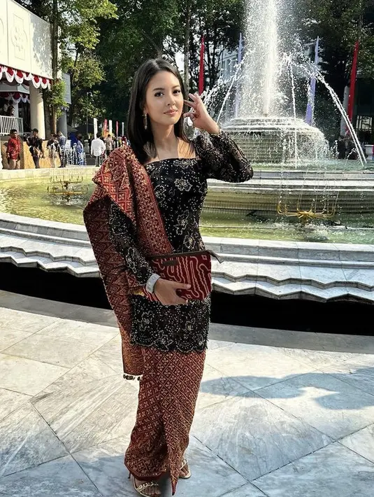 Aurelie tampil elegan dengan kebaya panjang hitam berpayet dipadukan kain songket Aceh untuk selendang dan kain dari Svarna by Ikat Indonesia.  [Instagram/@aurelie]